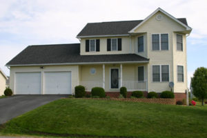 A yellow two-story Colonial house with a garage in Ranson, WV.