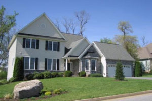 A two-story house constructed with siding and stone.