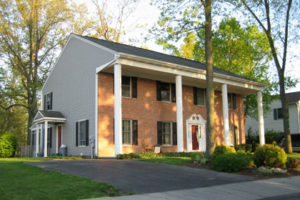 A two-story brick house with columns in the front.