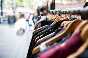 Clothes hanging on a rack in front of a store.