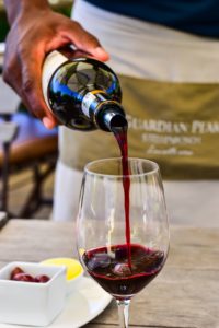 Man pouring a glass of red wine on a hot summer's day