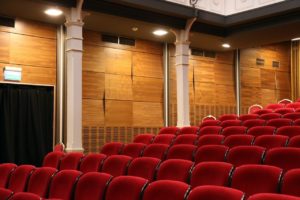 Empty theater with plush red seats.