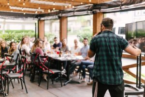 A mean speaking to a group of people in a cozy restaurant