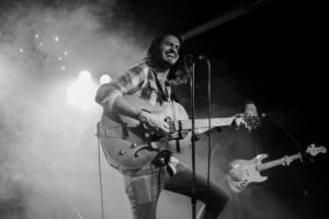 A man playing guitar on stage. 