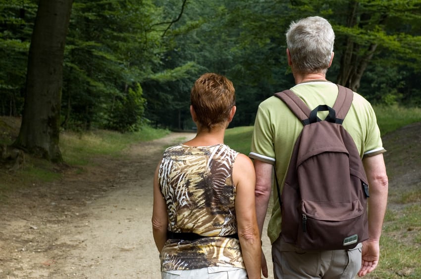 An older couple looking ahead at a nature trail.
