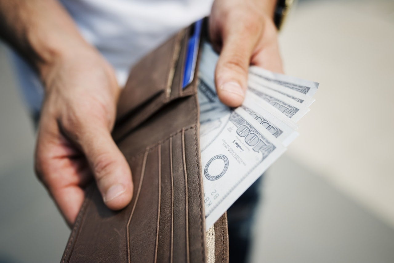 A person holding a stack of bills.