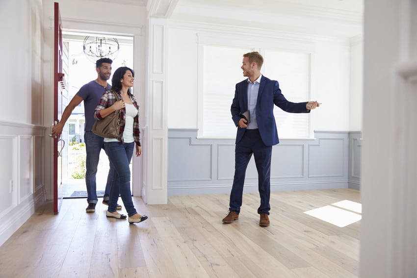 A couple touring a home with a real estate agent.