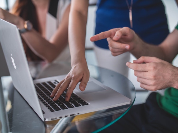 People meeting around a laptop.