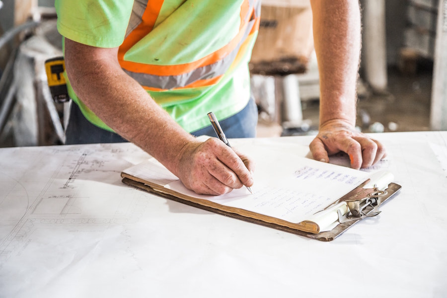 Construction worker writing on a clipboard